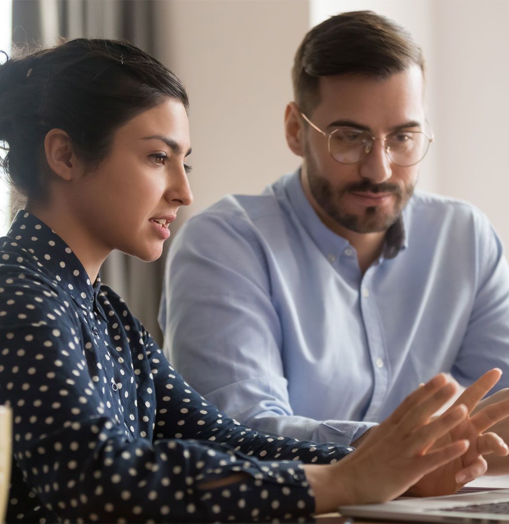 Accountant showing a business owner some figures on a laptop