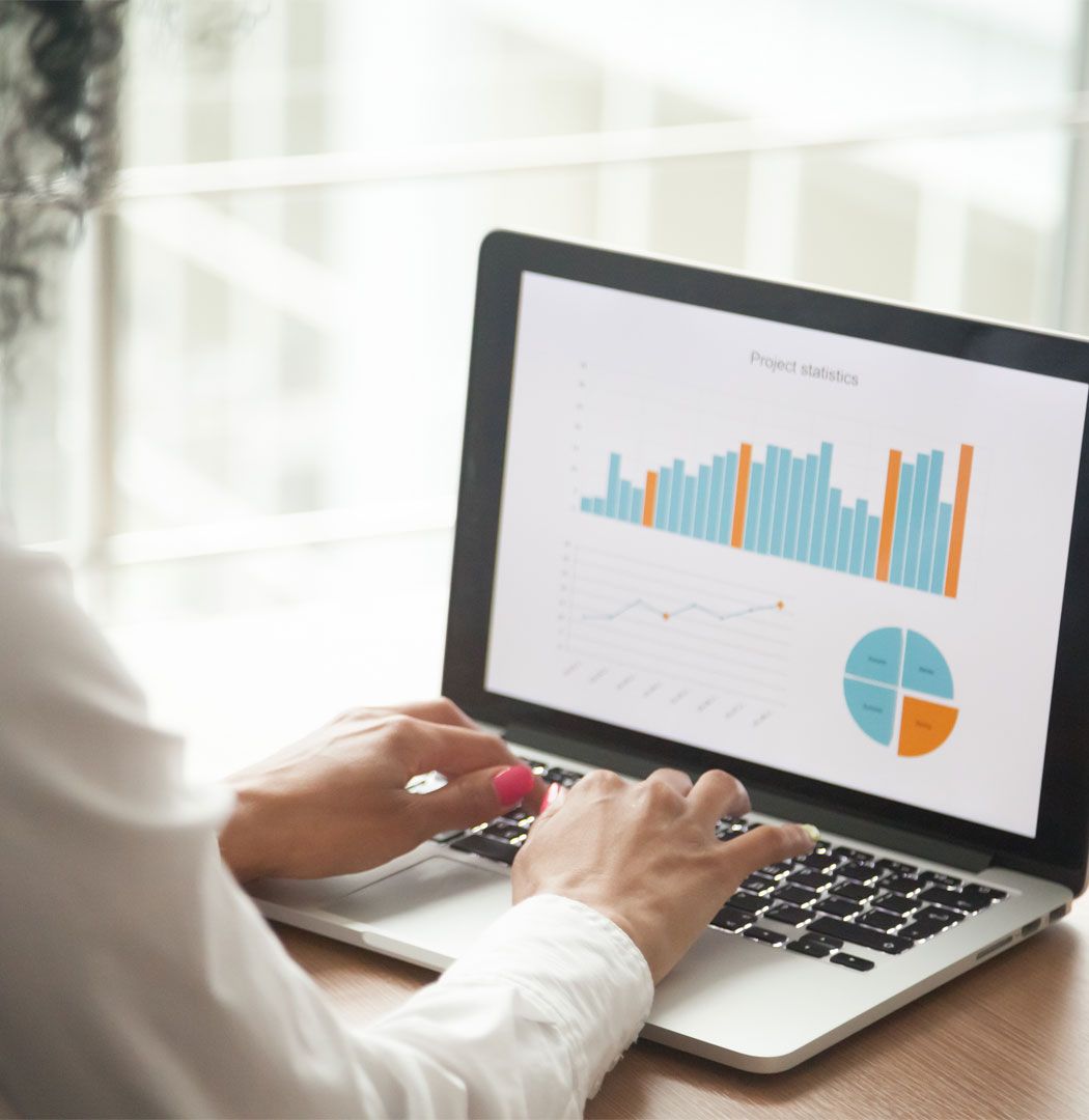 Accountant compiling a slide with charts and statistics on a laptop