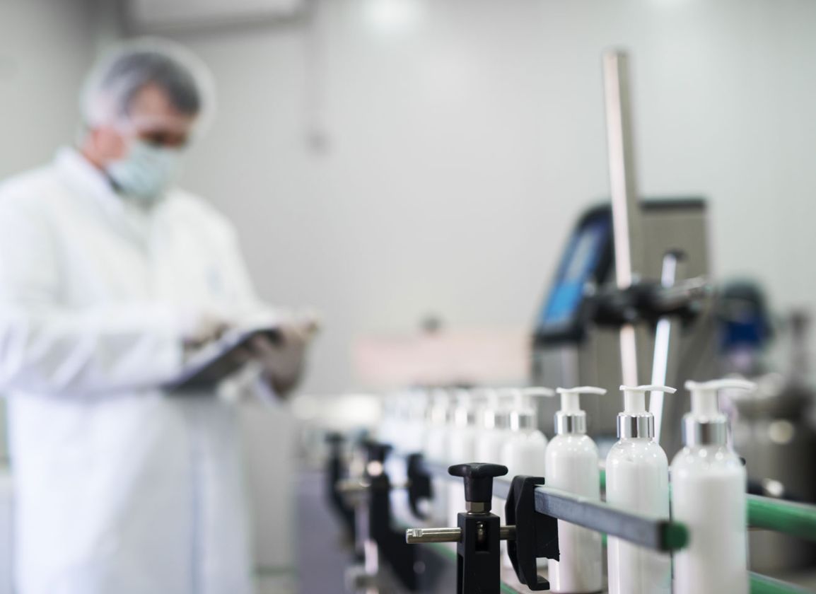 Technician quality checking a conveyor belt of bottles