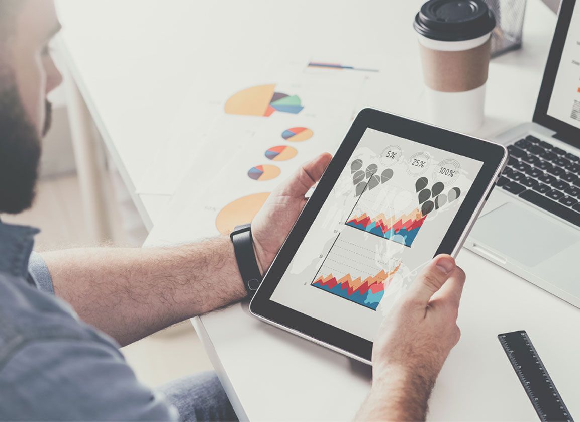 Business owner viewing a selection of graphs on a tablet