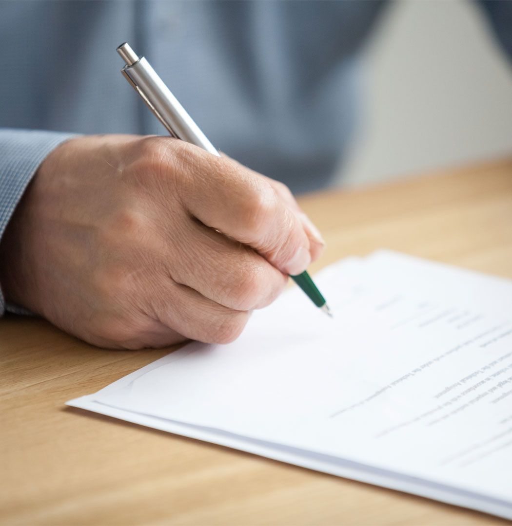 Individual taking notes during a meeting