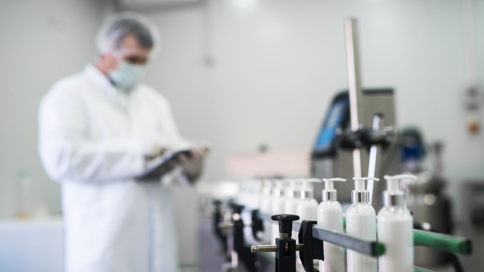 Worker quality checking products on a conveyor belt