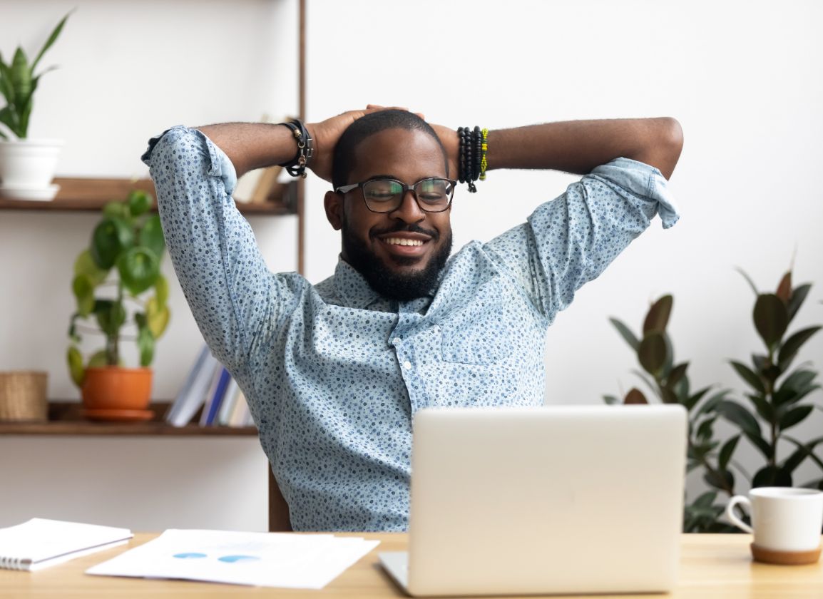 Business owner smiling at their laptop after receiving their R&D claim
